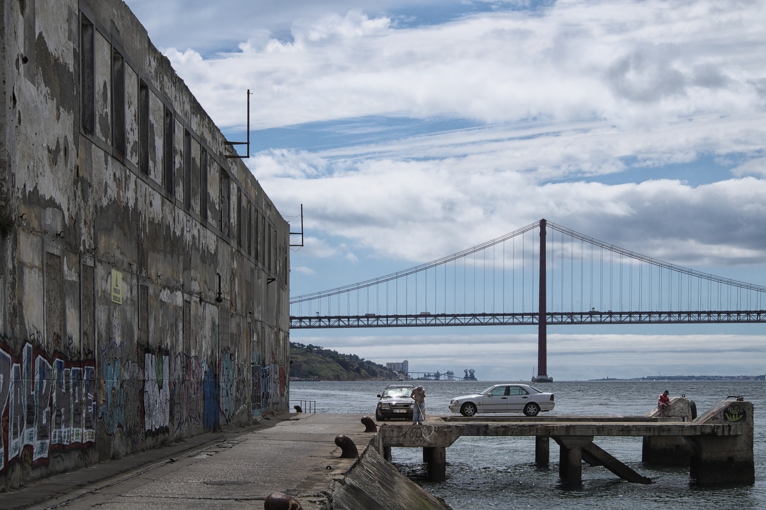 Alte, verlassene Kai-Anlagen mit Blick auf die Brücke Ponte 25 de Abril. In dieser verlassenen Gegend findet man höchstens einige einsame Angler... 